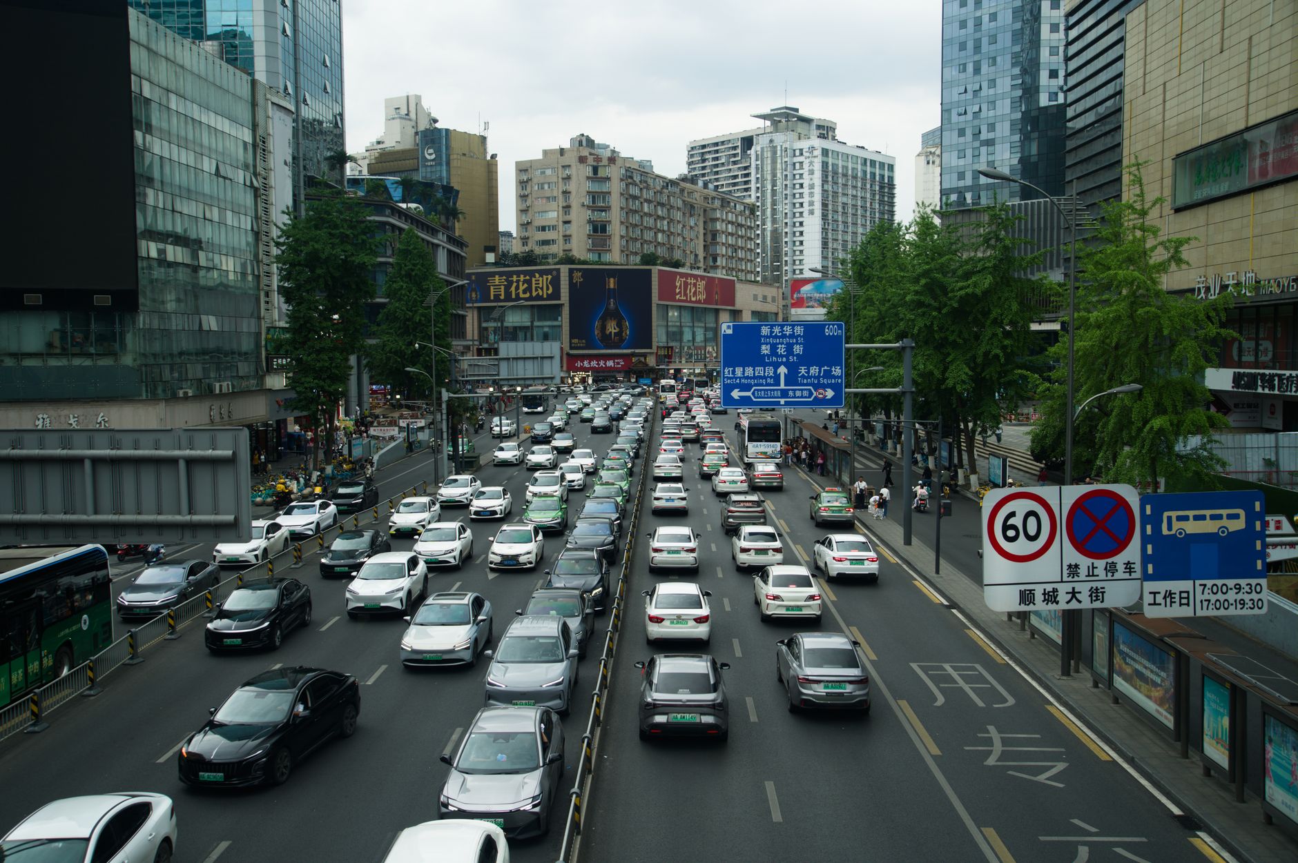 Heavy traffic on a busy Shanghai street lined with skyscrapers and billboards during the day. — Buy Credit Cards Online - Som