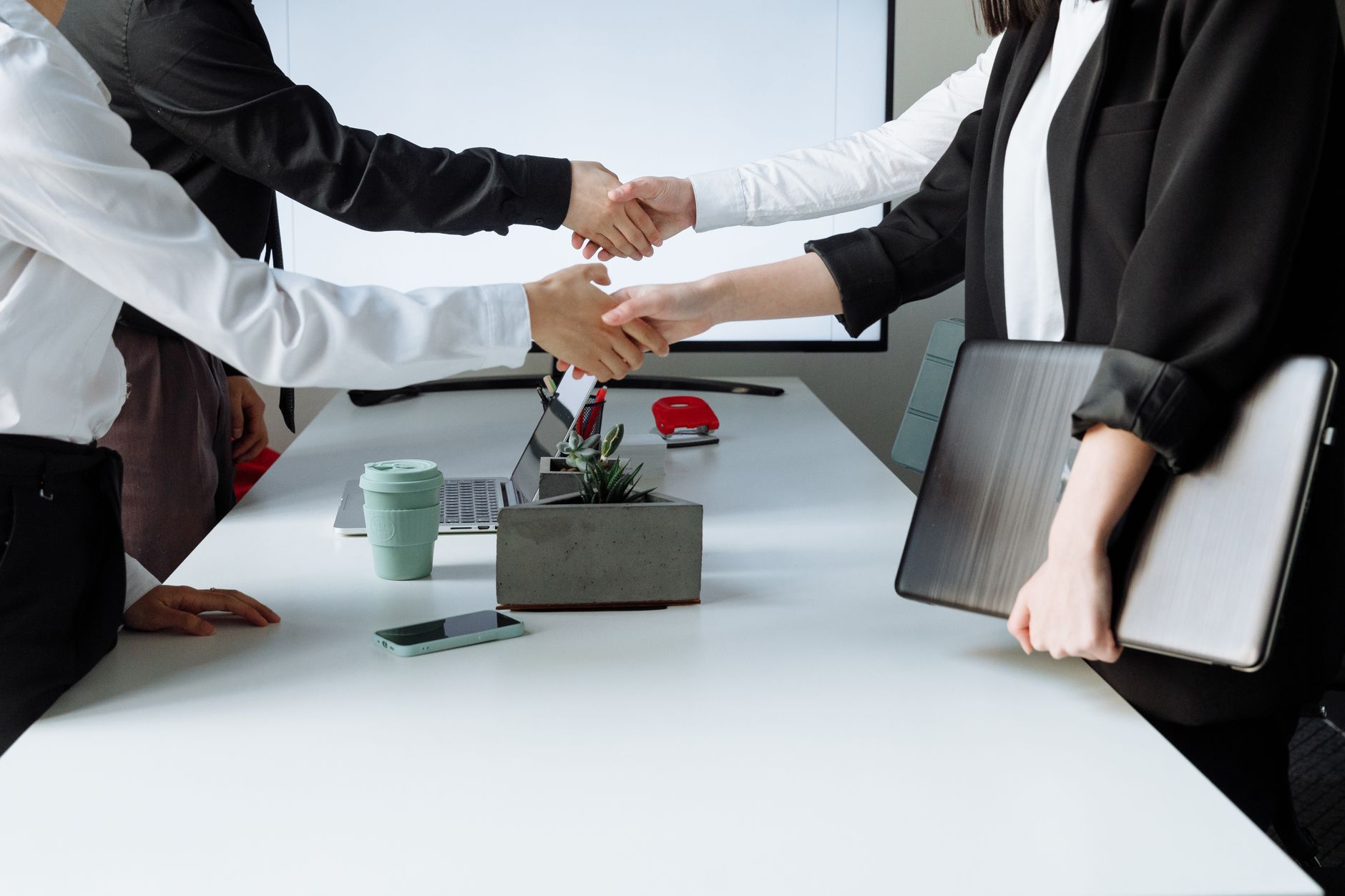 Professionals sealing a deal with a handshake across a conference table during a business meeting. — The Different Types of O