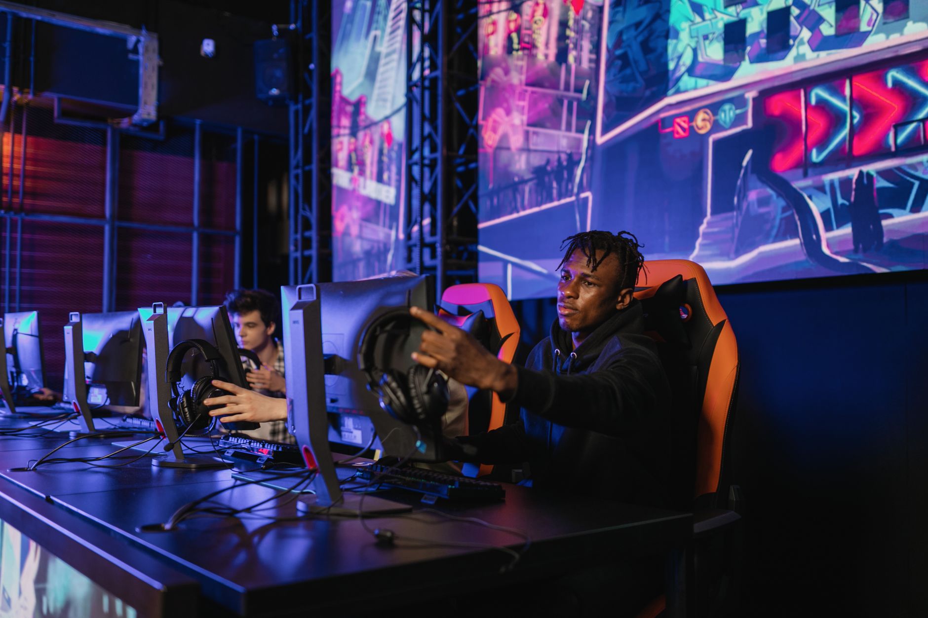 Two gamers intensely focused in a professional eSports competition with vibrant game visuals. — What are the available advant