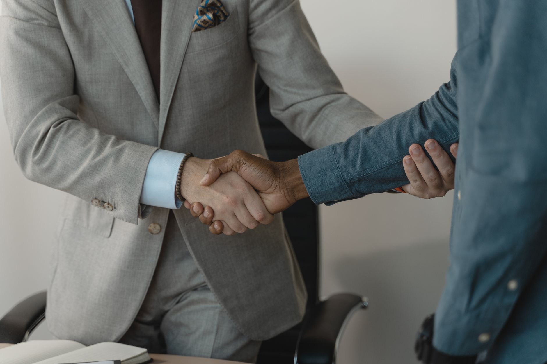 Image of a professional handshake between two businessmen in an office setting. — What are the different factors you need to