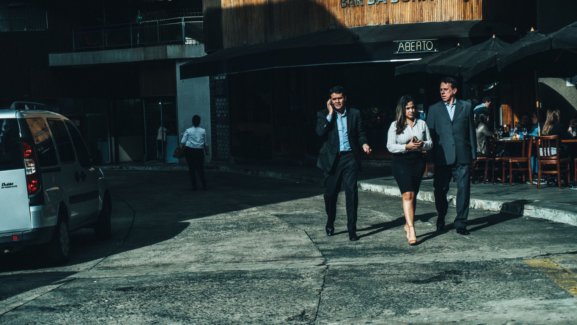 Three business professionals walk along a city street outside a cafe. — Why You Should buy kratom powder: The Most Comprehens